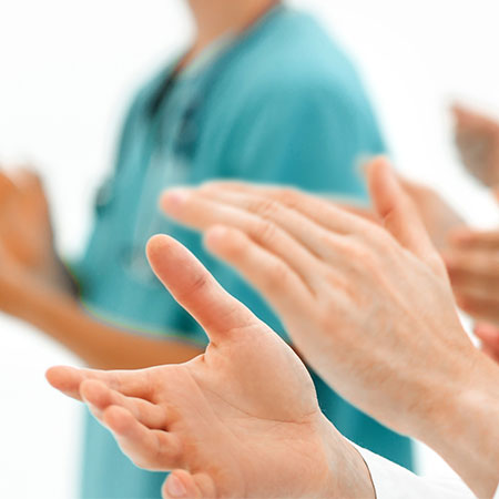 A group of hands of medical personnel applauding