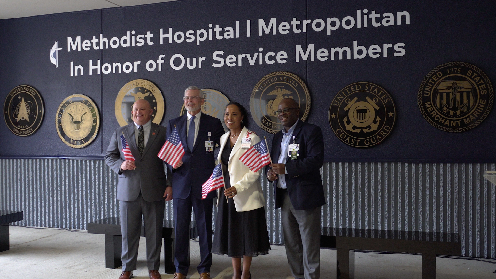 Methodist Hospital Metropolitan unveils Tribute Wall to Veterans outside of the hospital with a group of people.