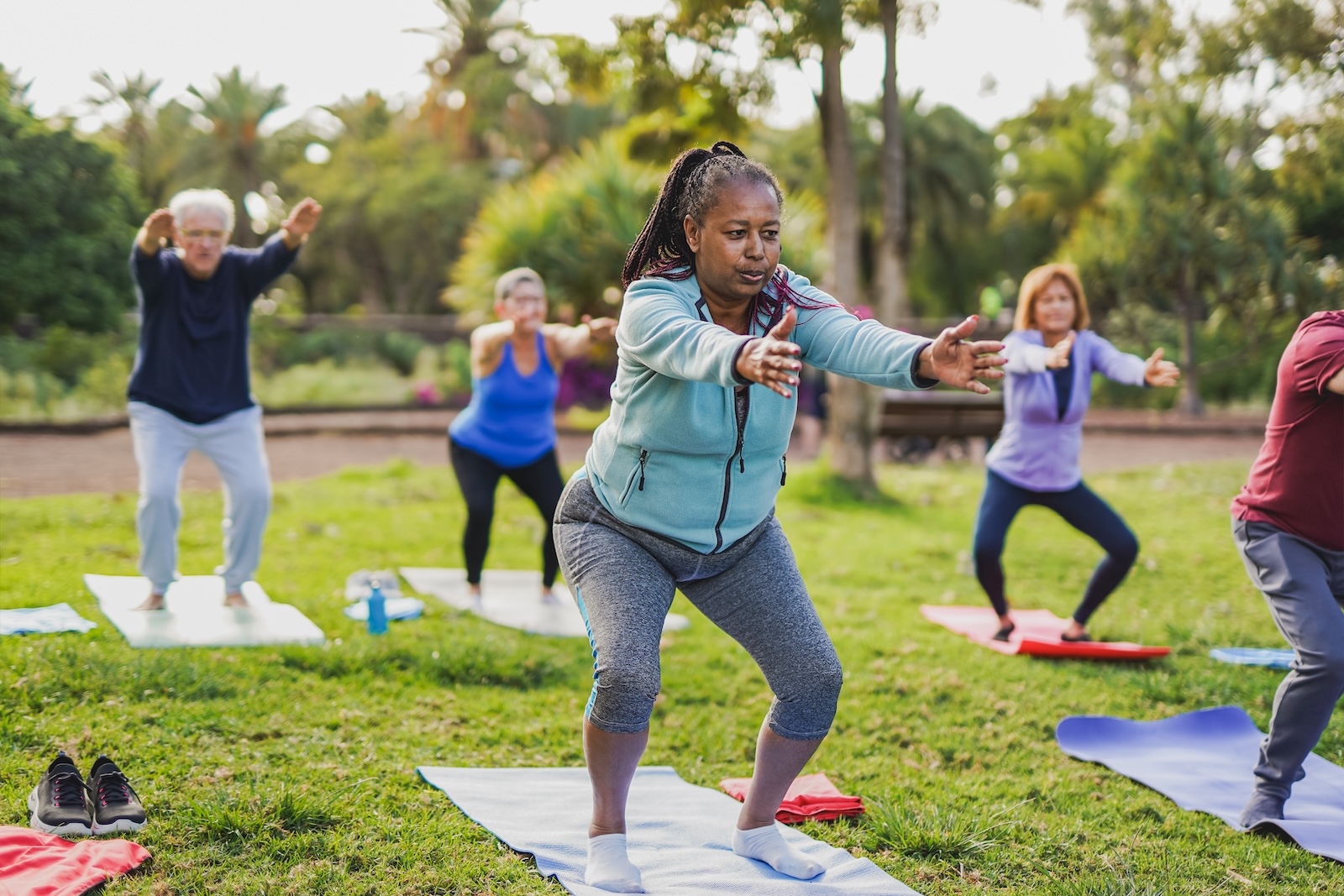 A group of elderly people doing yoga in the park.