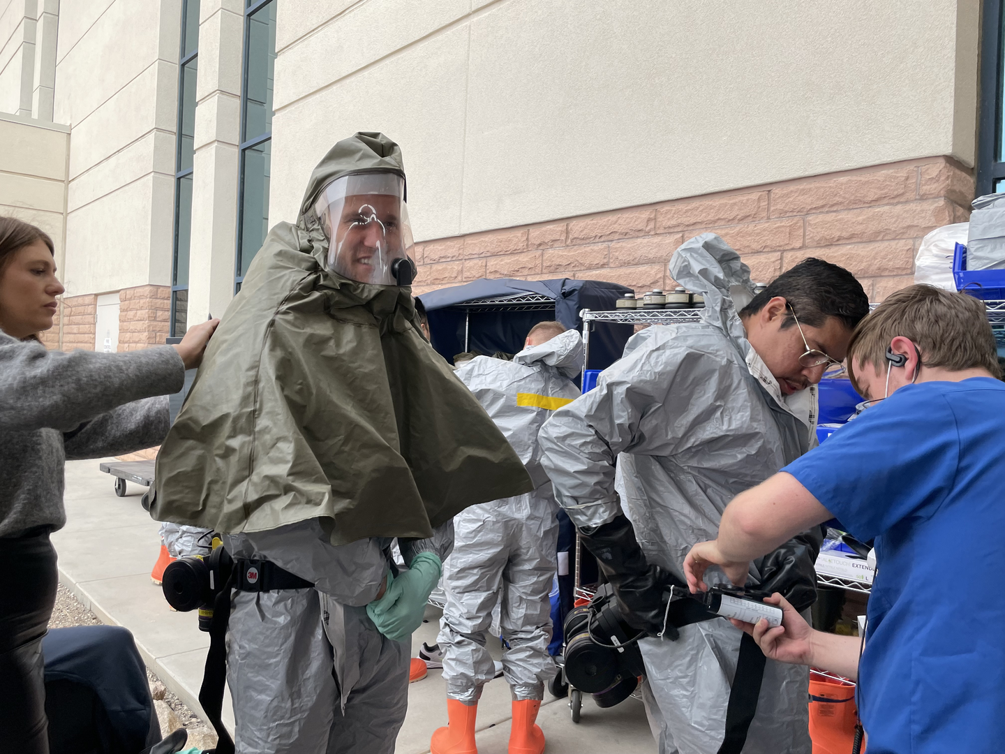 People gather outside to put on hazmat suits.