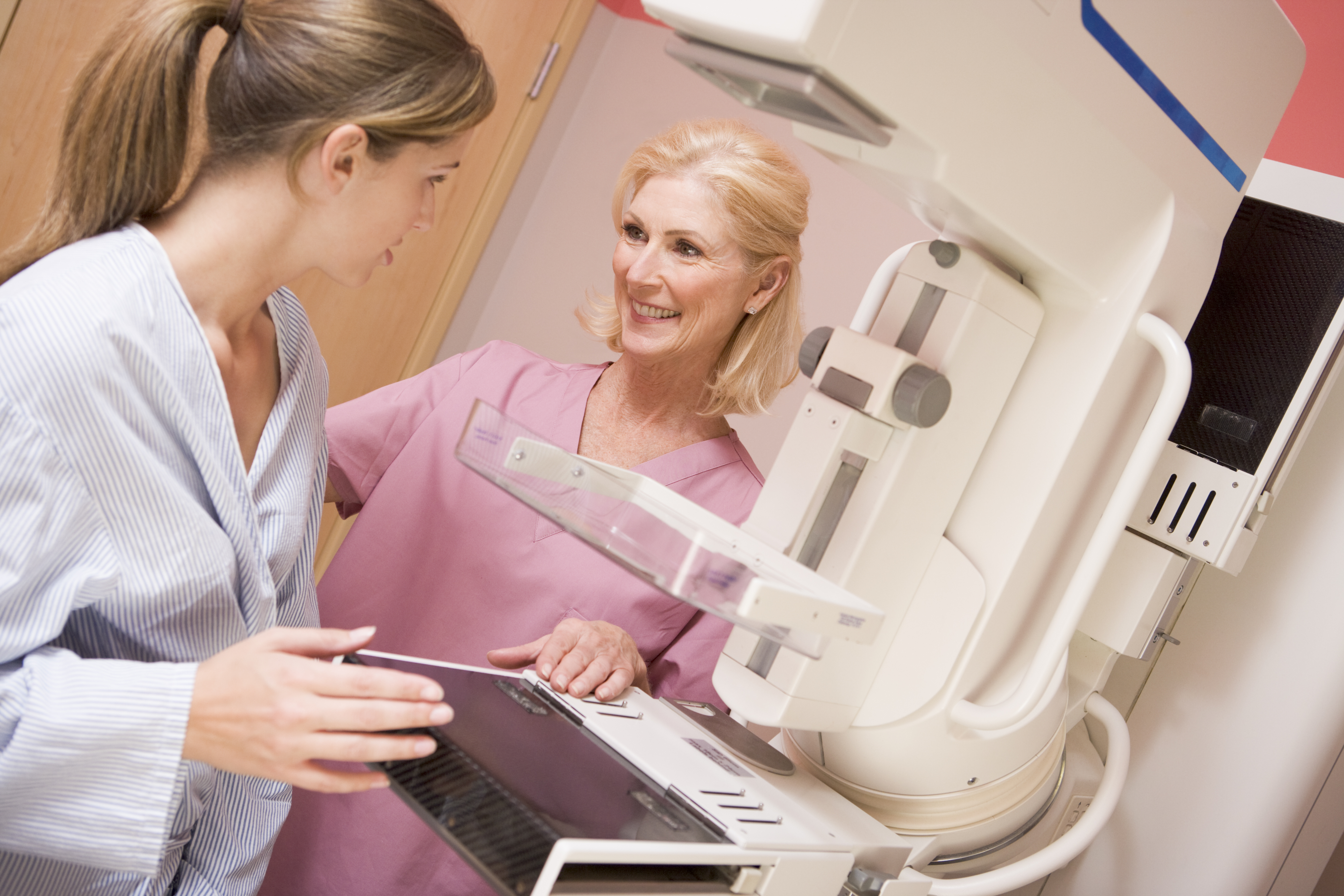 A female patient is consulted by female mammogram technician