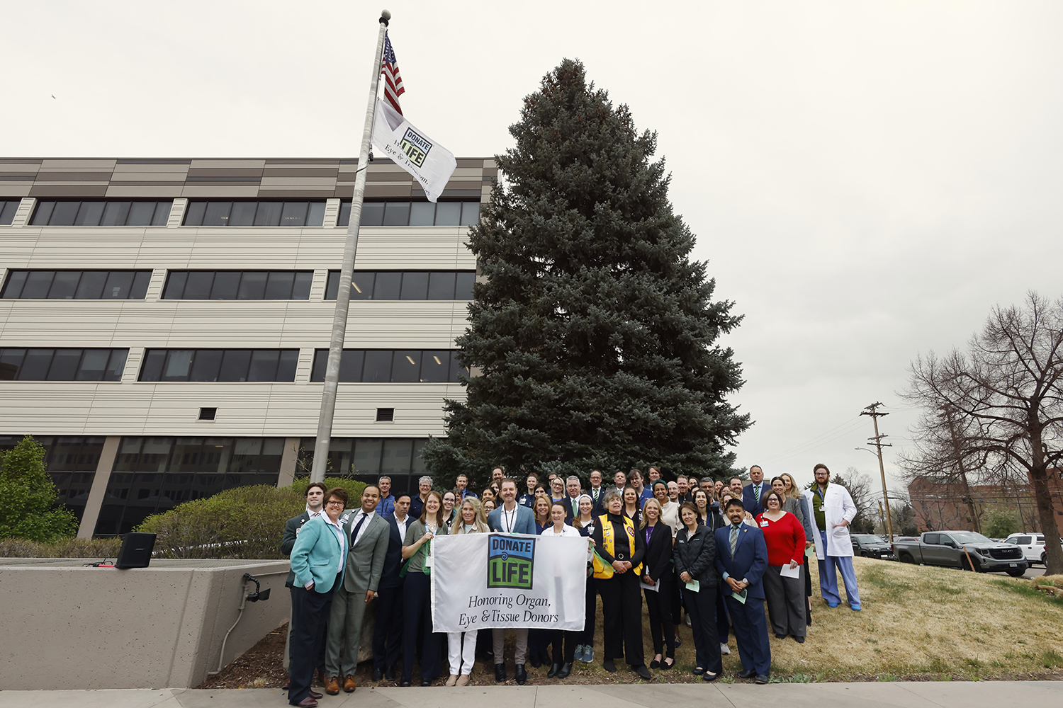 The leadership team at HCA HealthONE Presbyterian St. Luke's gathers for the Donate Life Month flag raising ceremony.