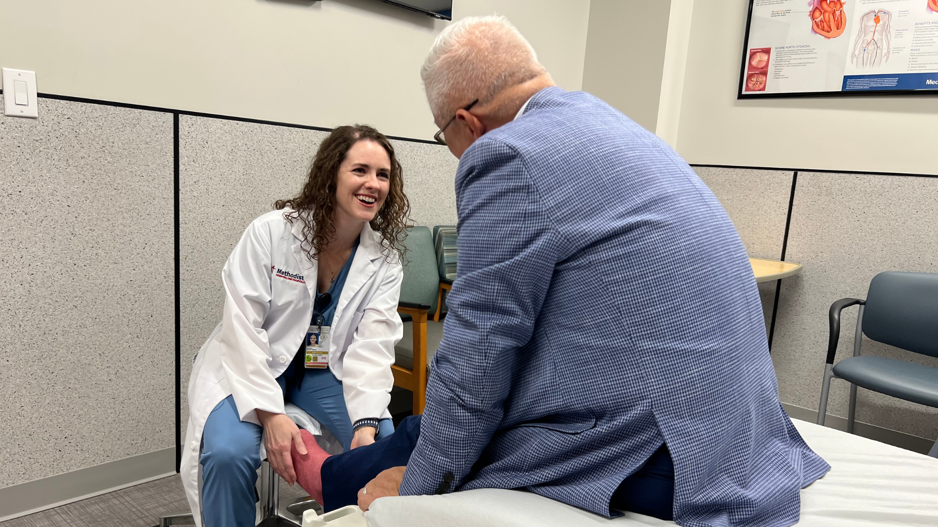 Doctor smiles with patient during exam.