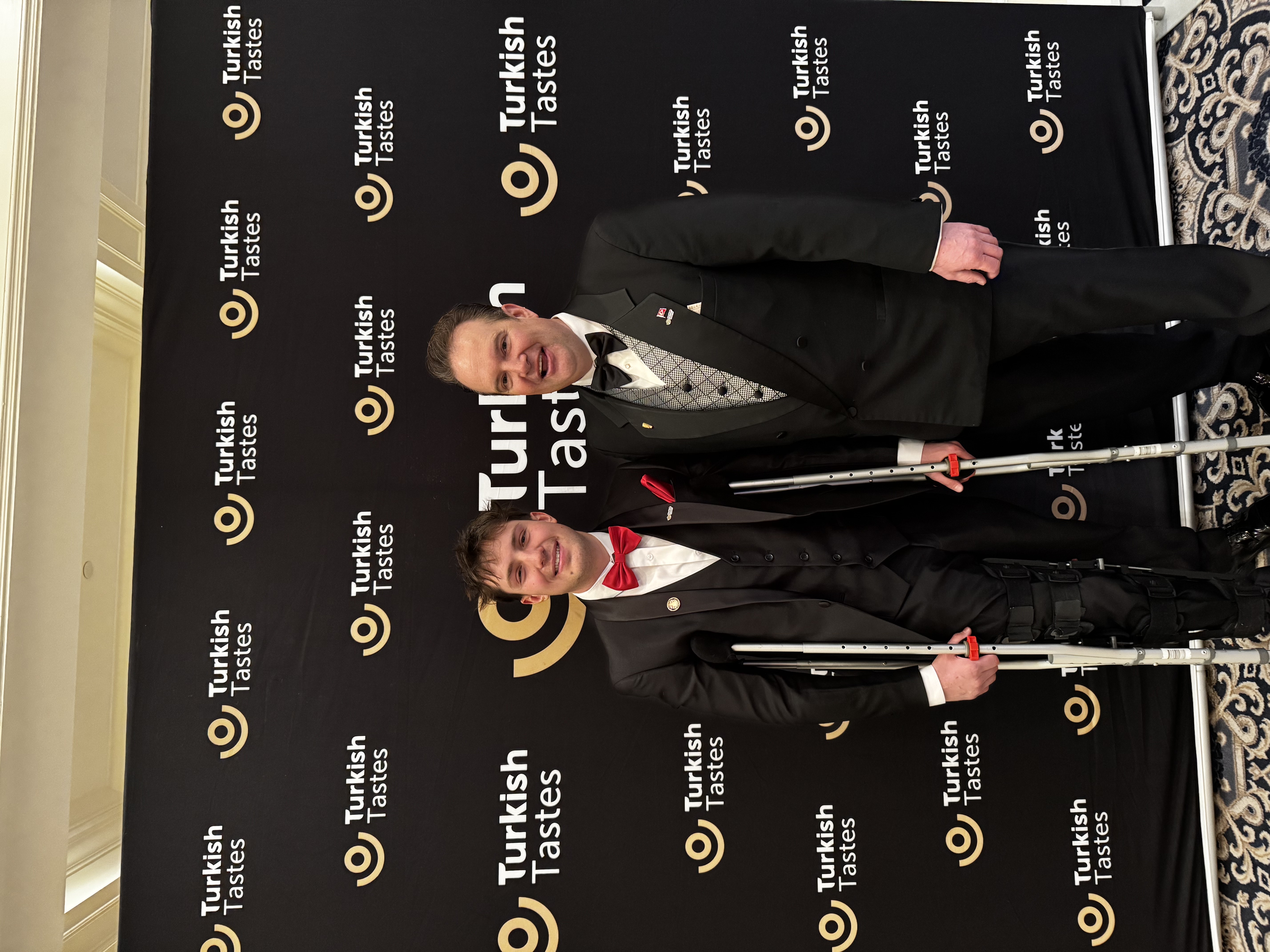 Zach on crutches at formal event.