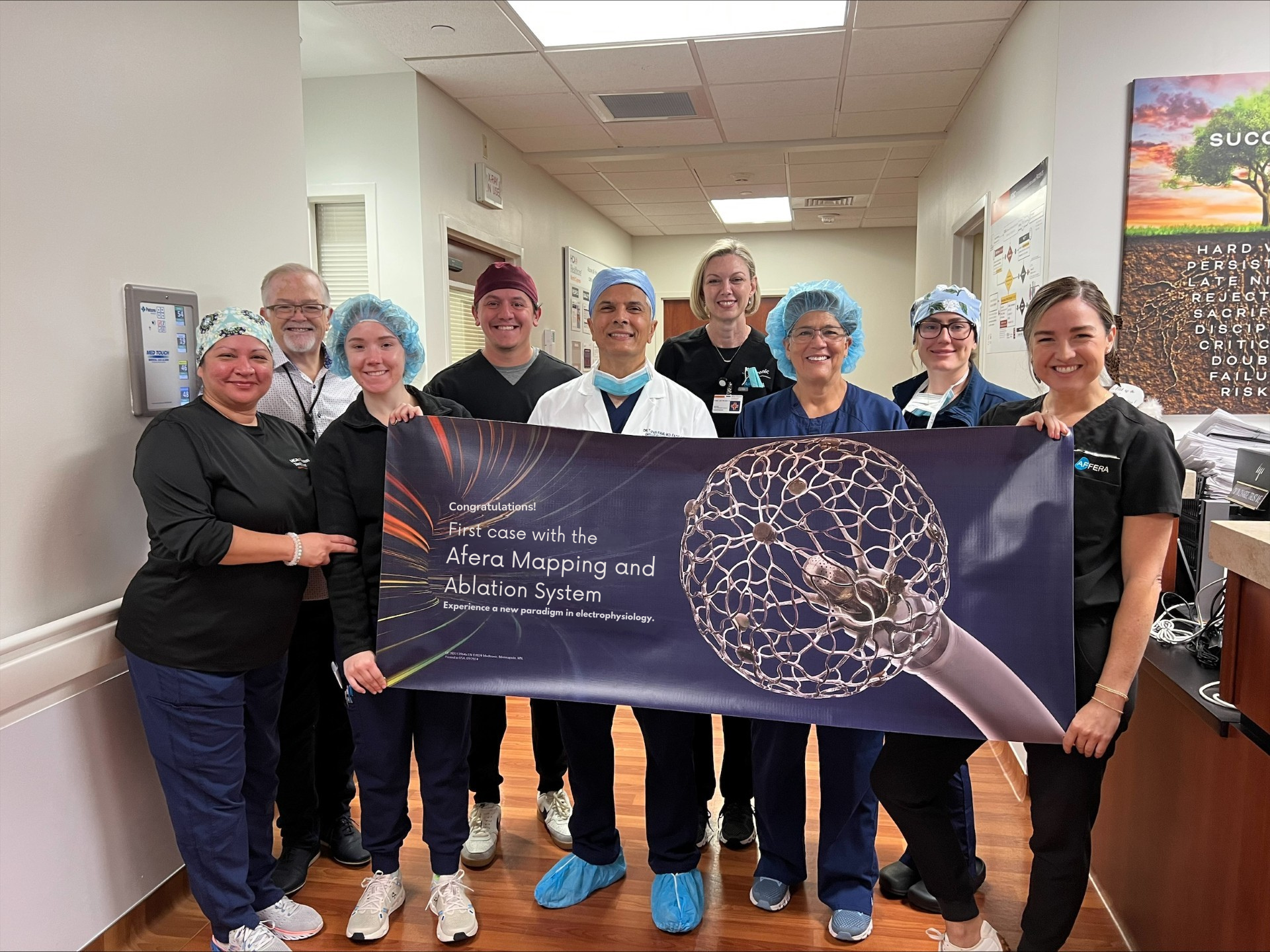 A group of HCA employees hold a banner inside the hospital.