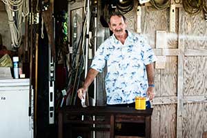 Larry Poff working in a workshop painting a table