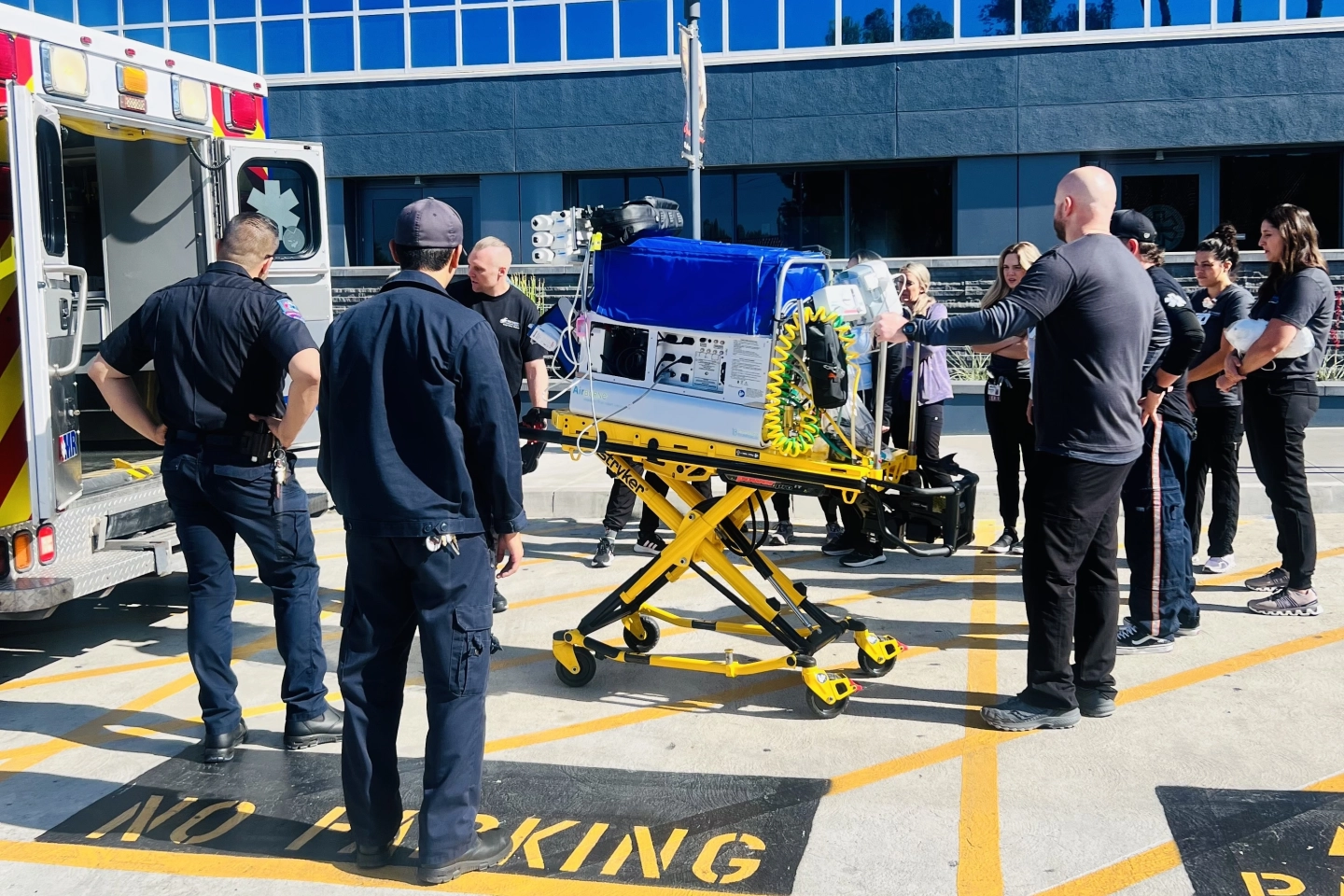 The NICU Transport team continuing to unload the specialized transport patient bed.