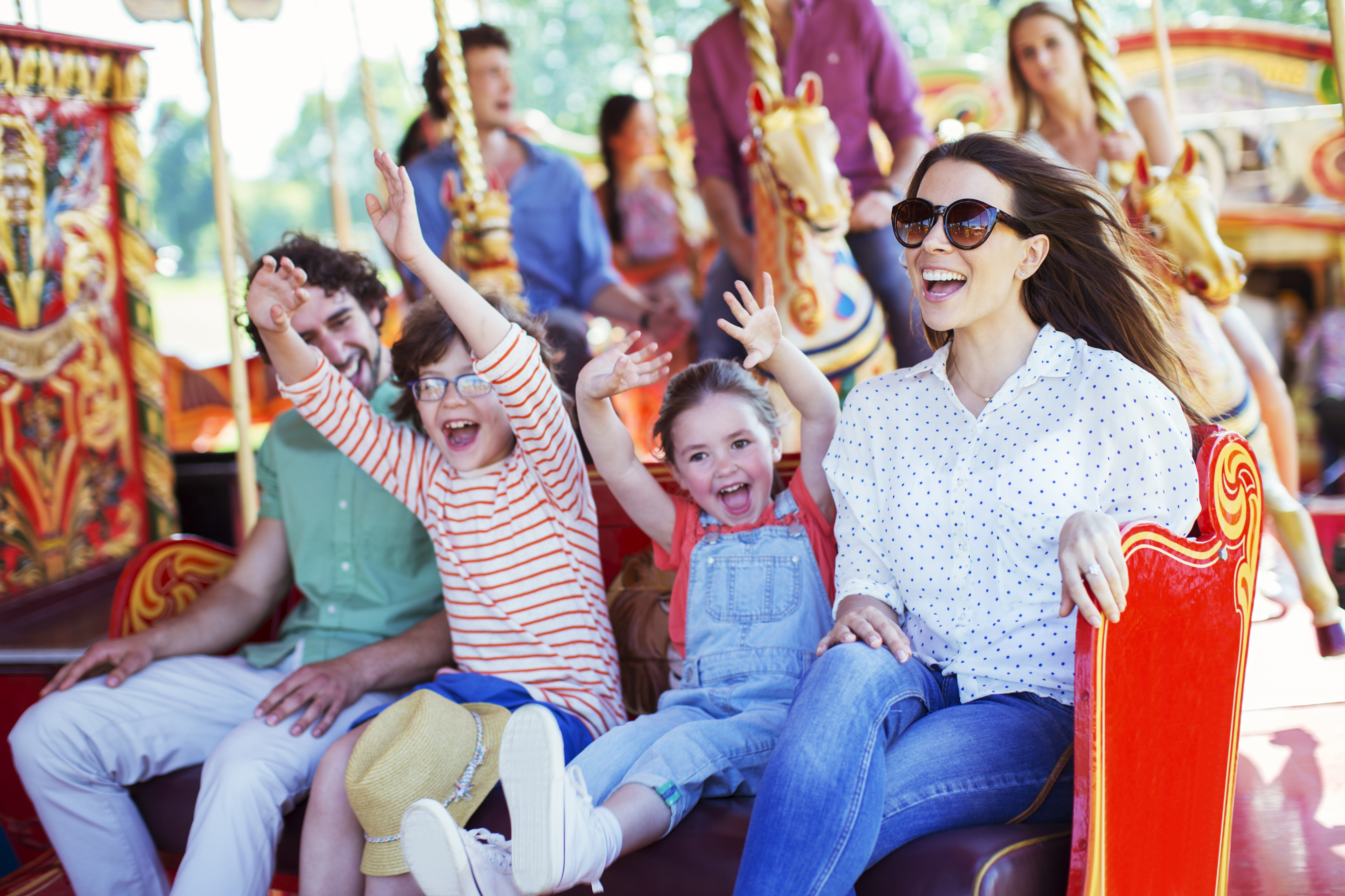 A family rides a carousel in an amusement park.