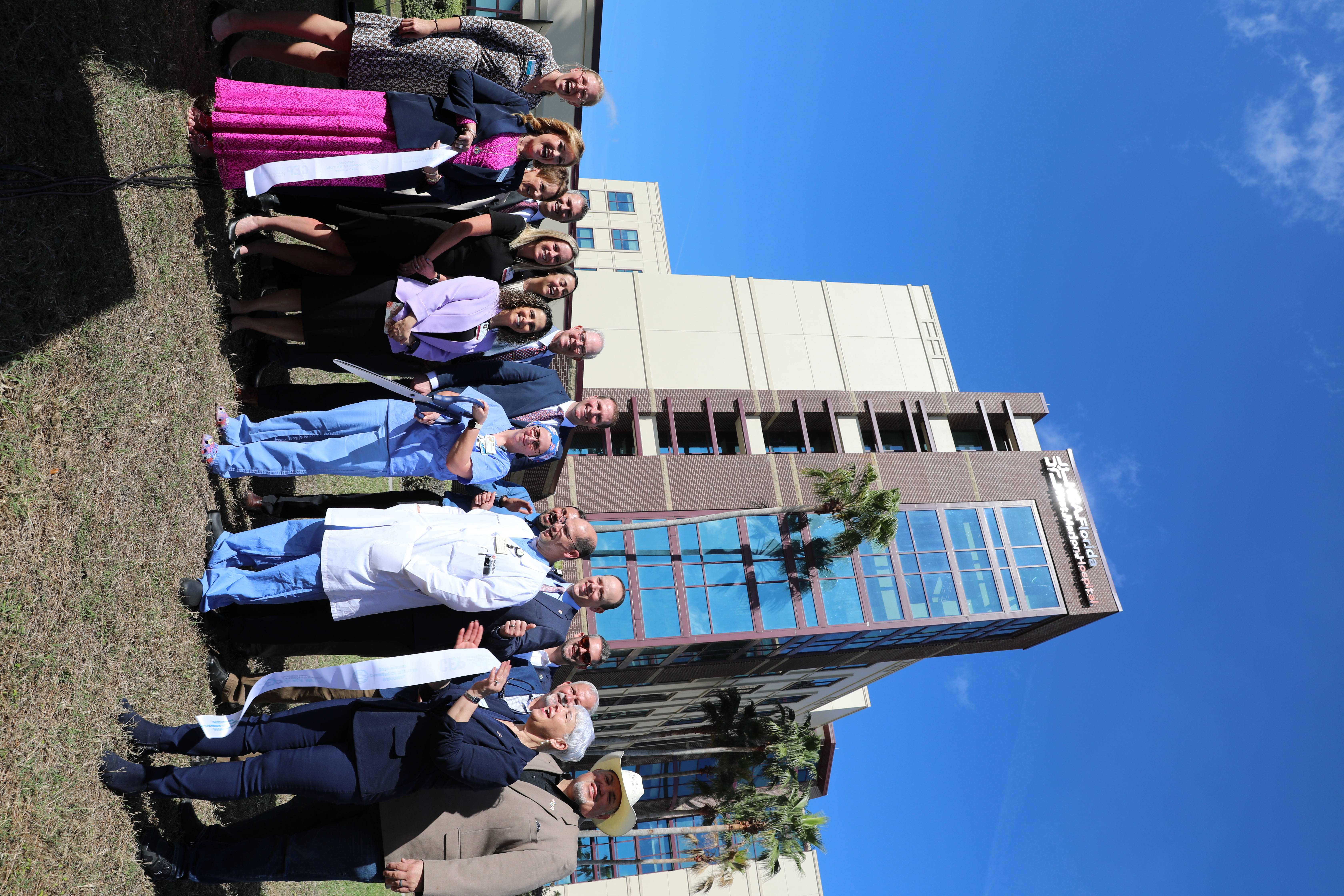 Group of people participating in the opening celebration in front of the HCA Florida West Marion Hospital building.