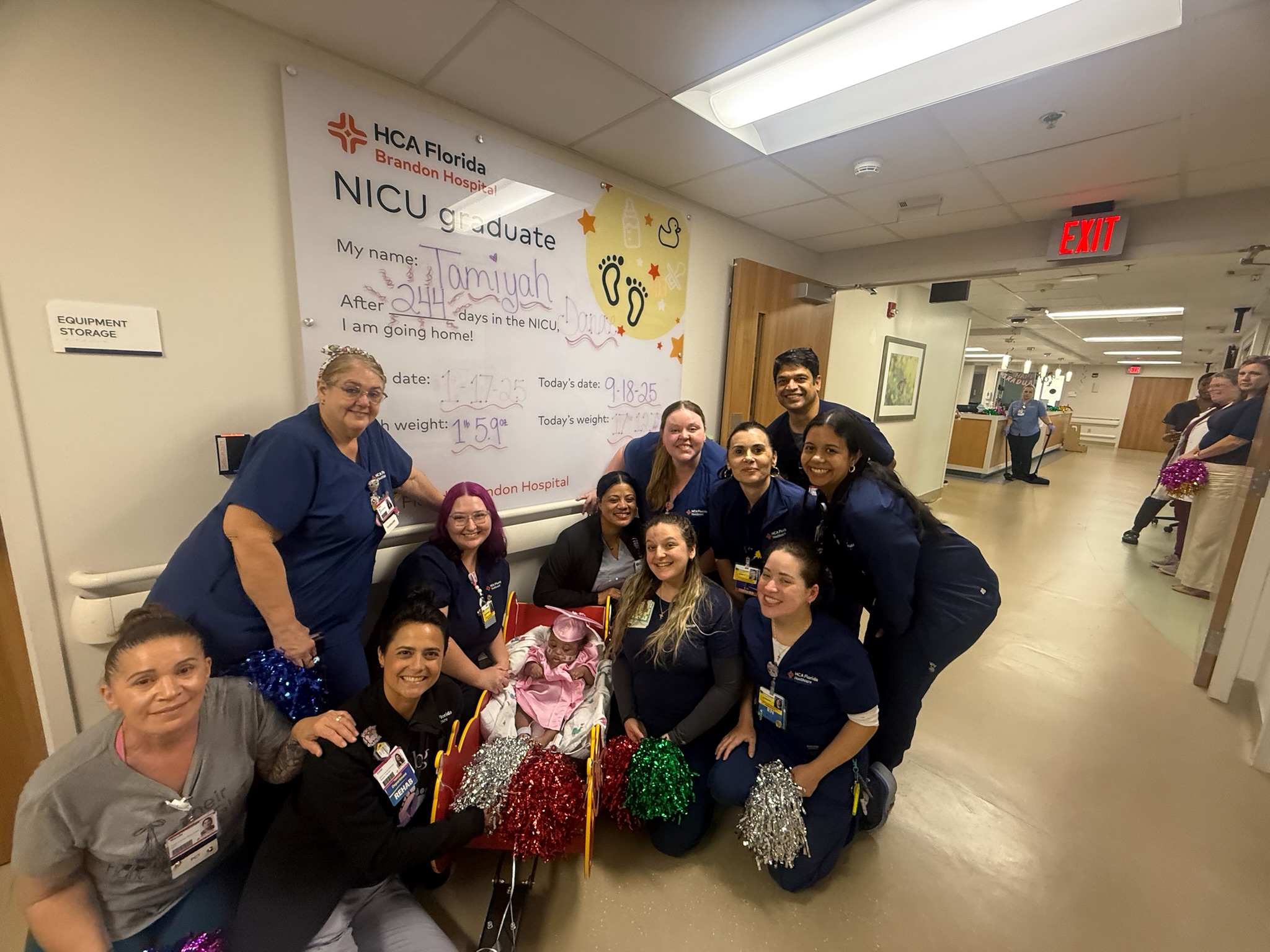 Nurses and Tamiyah's mom stand around the baby celebrating her NICU graduation
