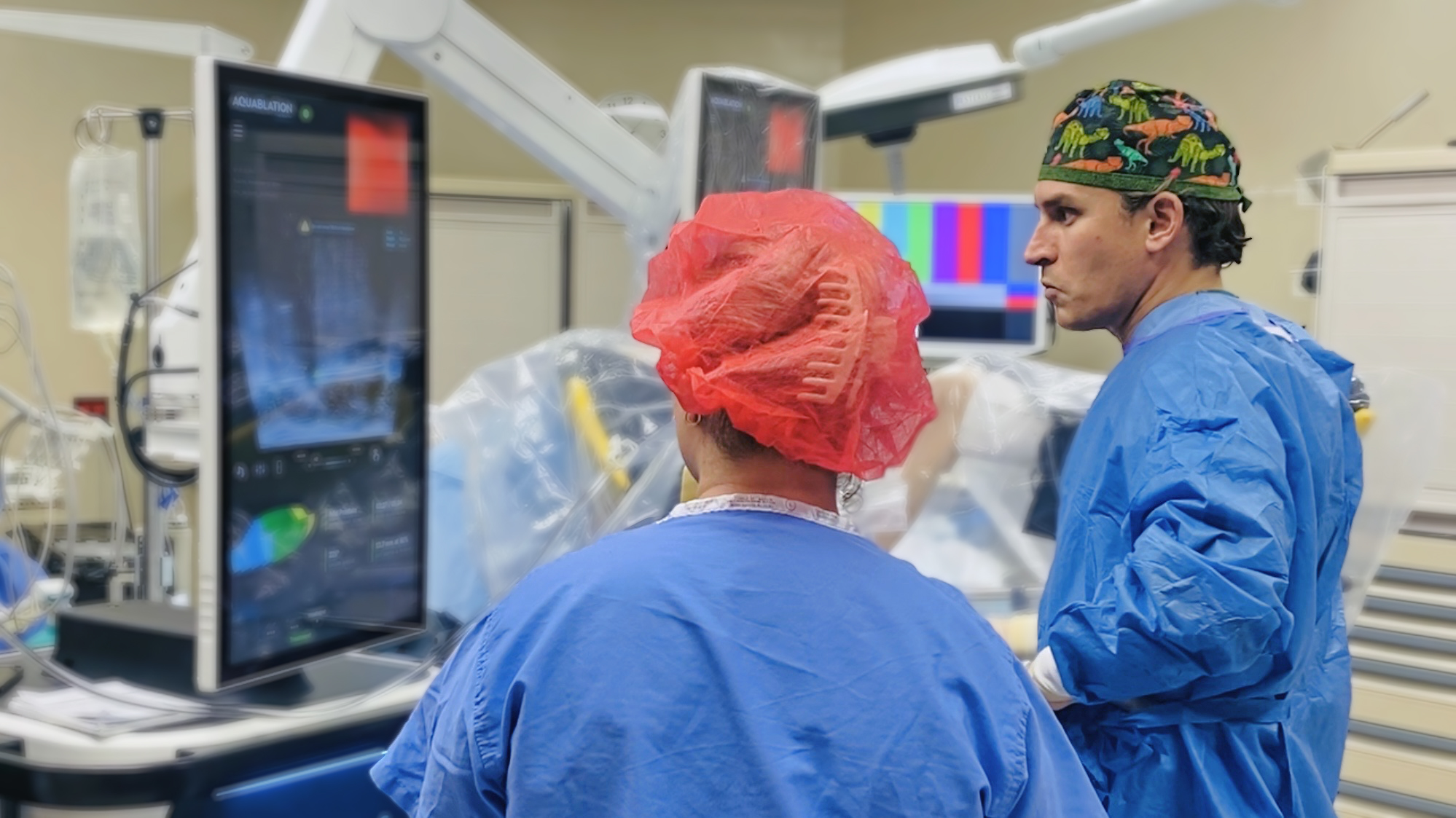 Two doctors in operating room using robitc assisted surgery machone.