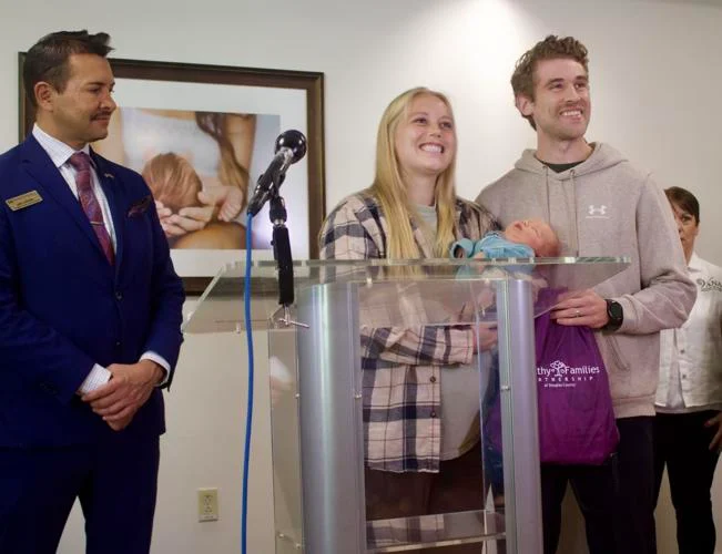 Sky Ridge family receives a sleep sack during Healthy Families announcement.