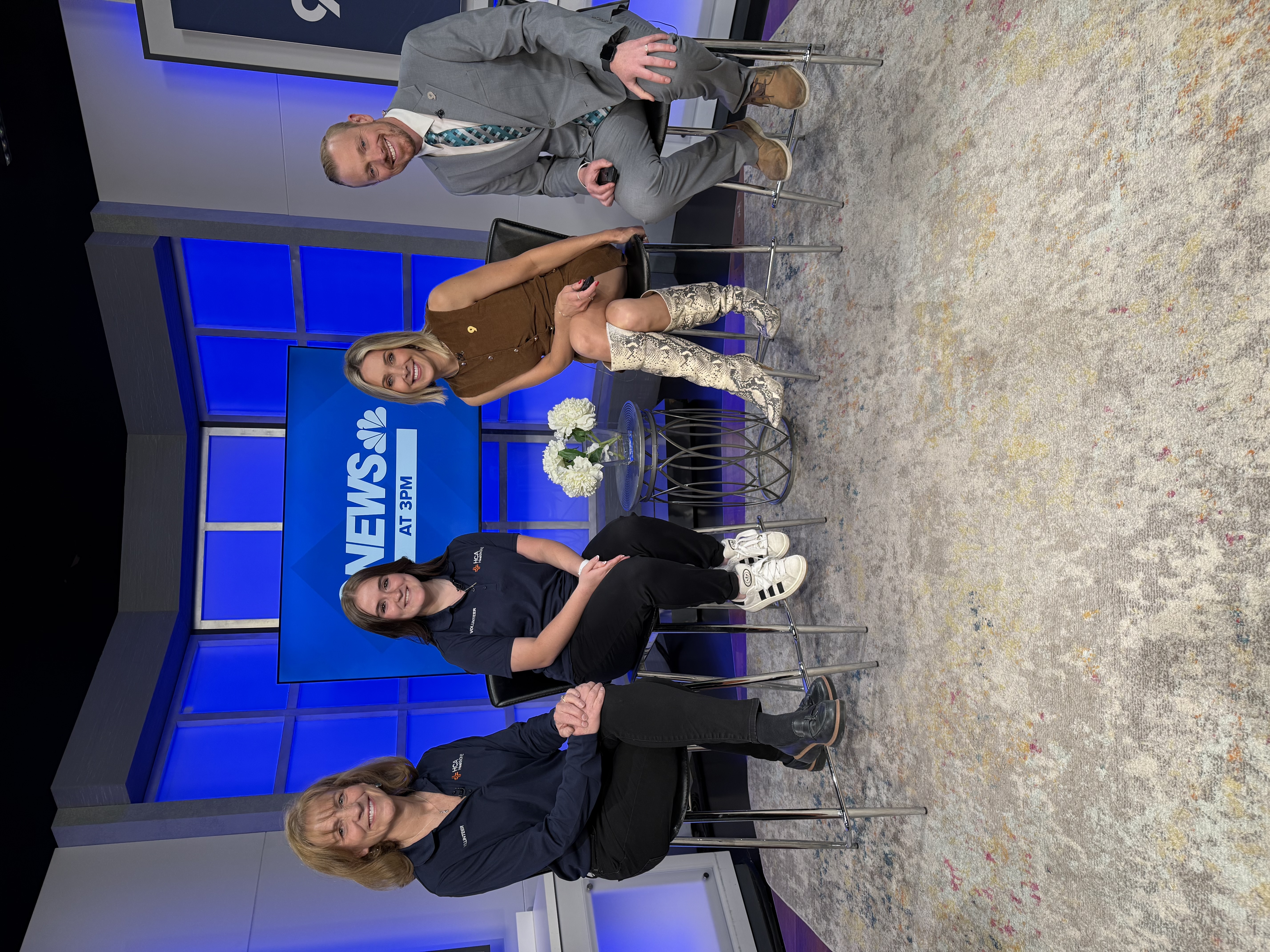 Photo showing of two female volunteers in the studio with 9News hosts, smiling for a photo.