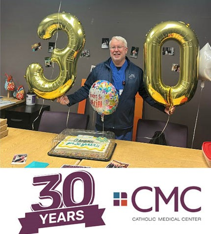 Rich MacNeil smiles while holding two mylar balloons that are a "3" and a "0" with a celebration cake on the table in front of him. The Catholic Medical Center logo is below the picture, along with the text, "30 years."
