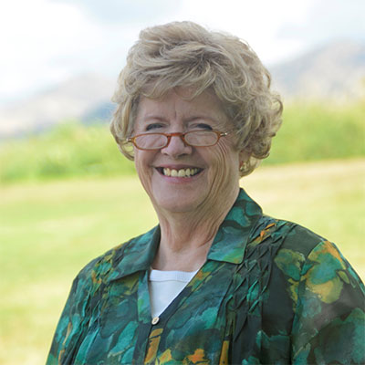 Janet Donnelly wearing glasses and smiling outside.