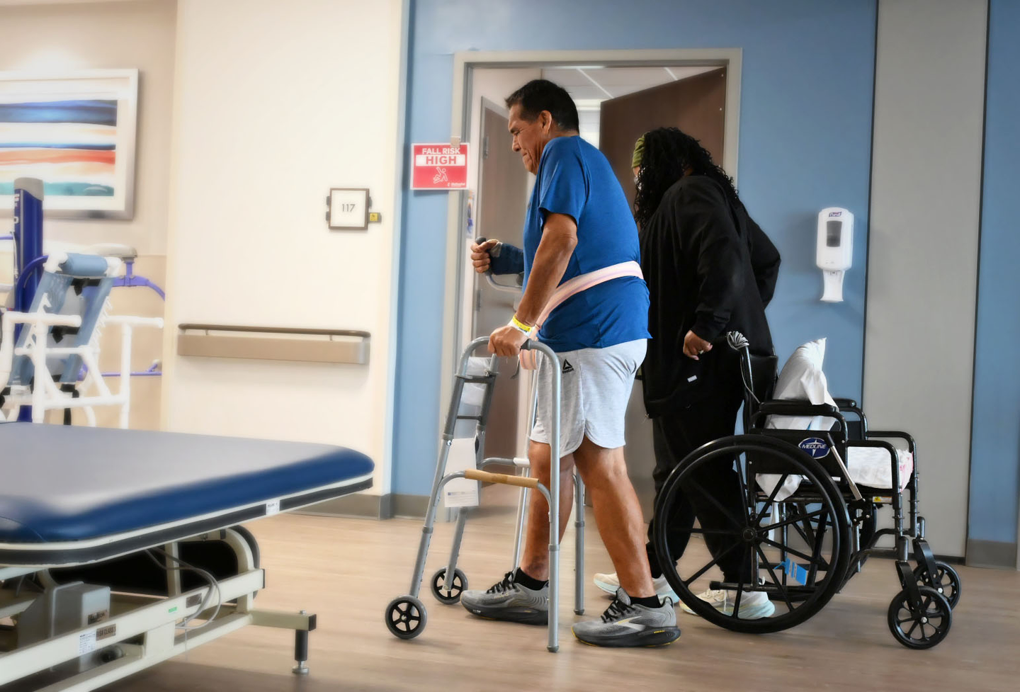 Physical therapist walking with a male physical therapy patient in Methodist Rehabilitation Hospital.