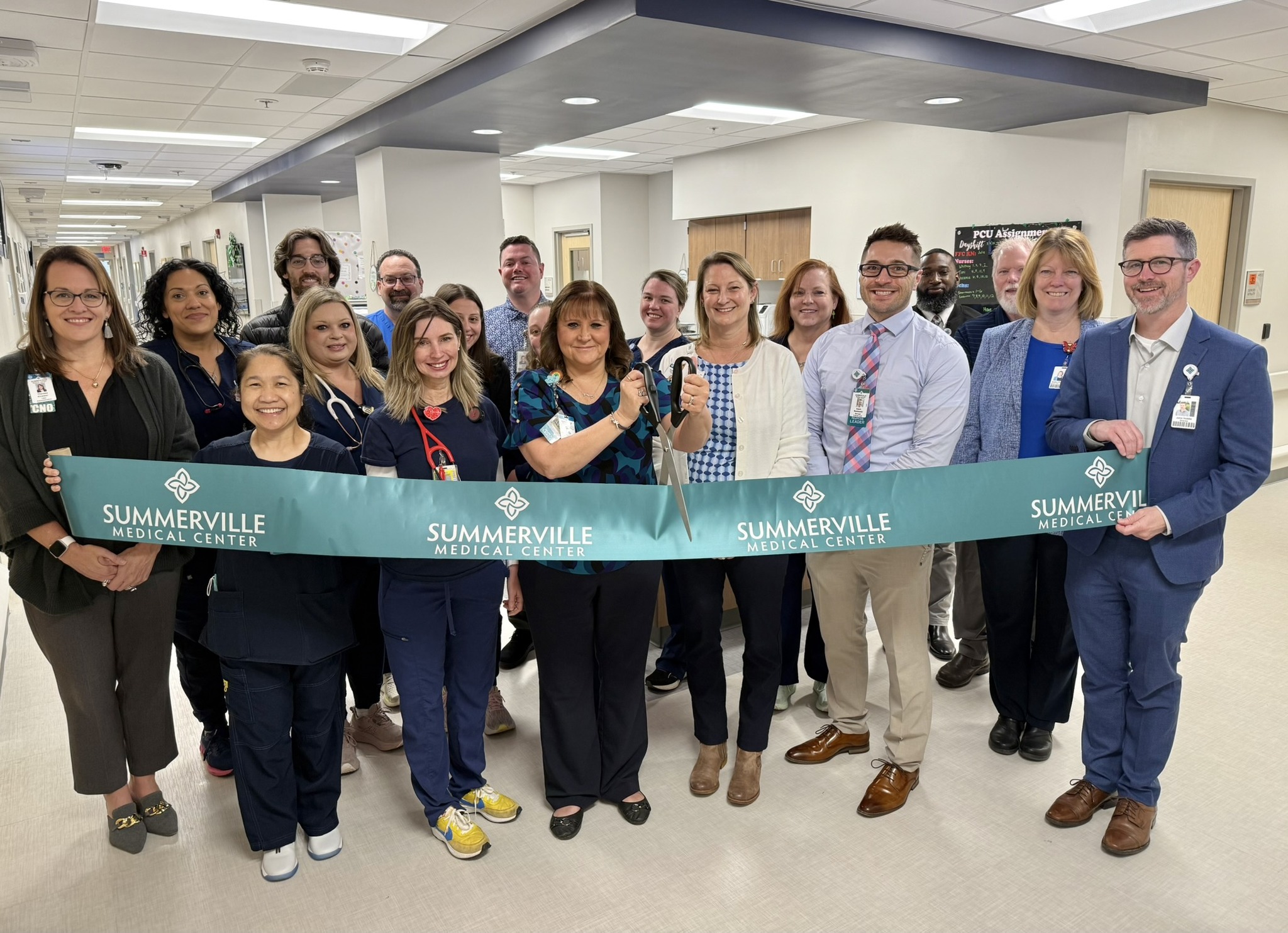 Summerville staff cutting large cyan ribbon in the lobby of the new inpatient expansion.