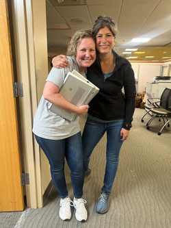 Mission Hospital HR member Jorie Matijevich and HCA Healthcare Capital Division Regional Vice President of Human Resources Nyema Sayed hug in an office.