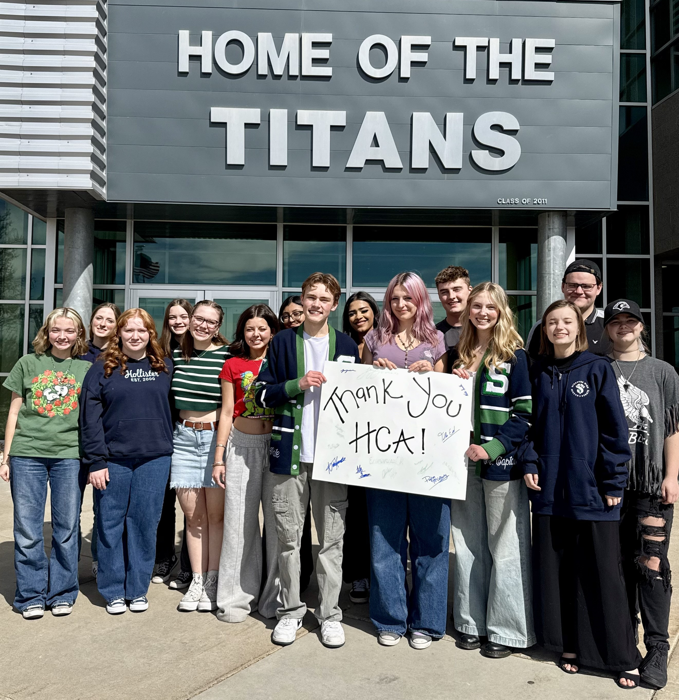 Photo of Syracuse High School Speech and Debate Team with a sign that reads "Thank you HCA"