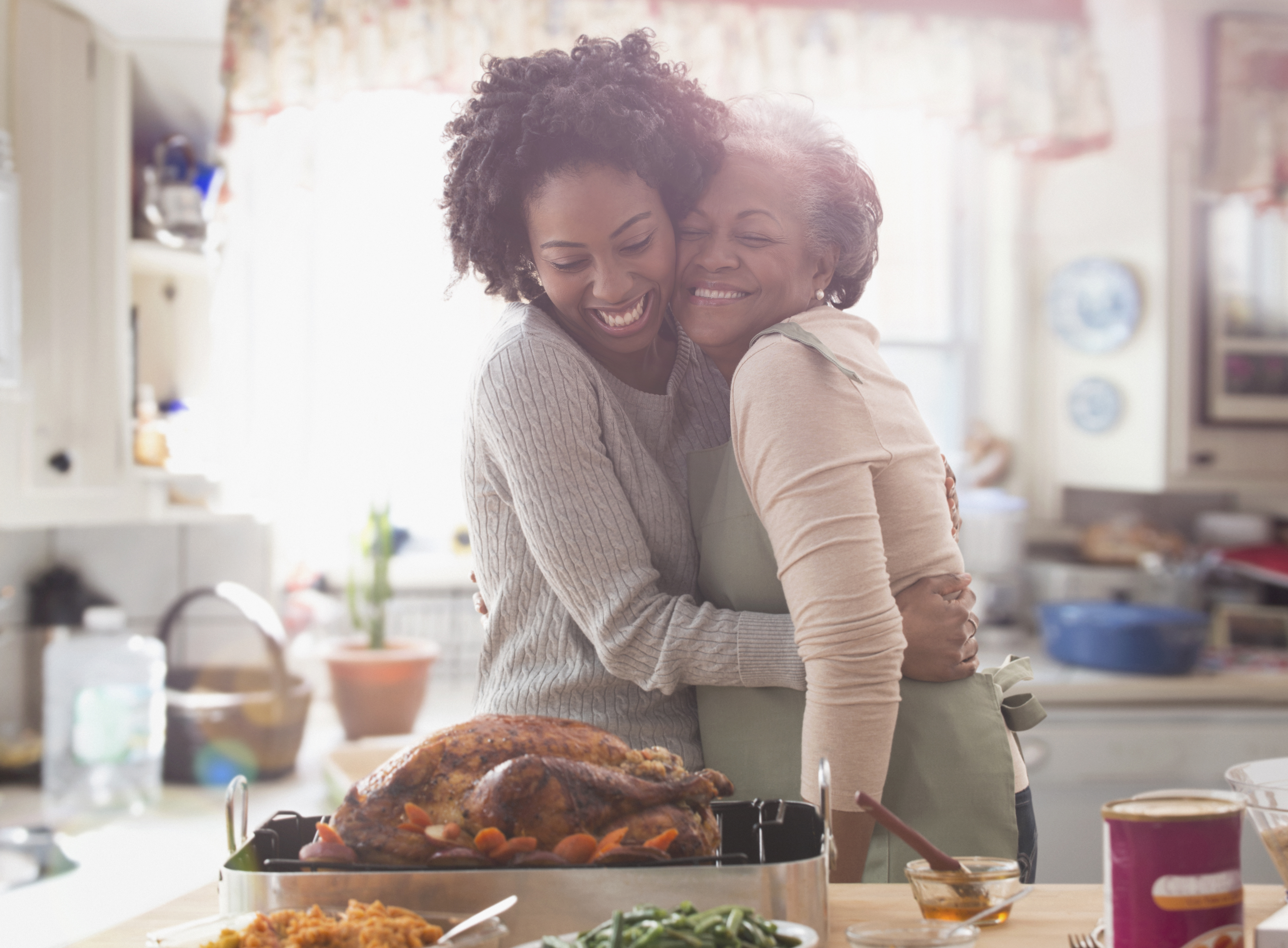 Two women embracing in kitchen