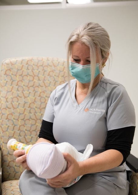 Jerrica Walden feeds a newborn with a bottle.