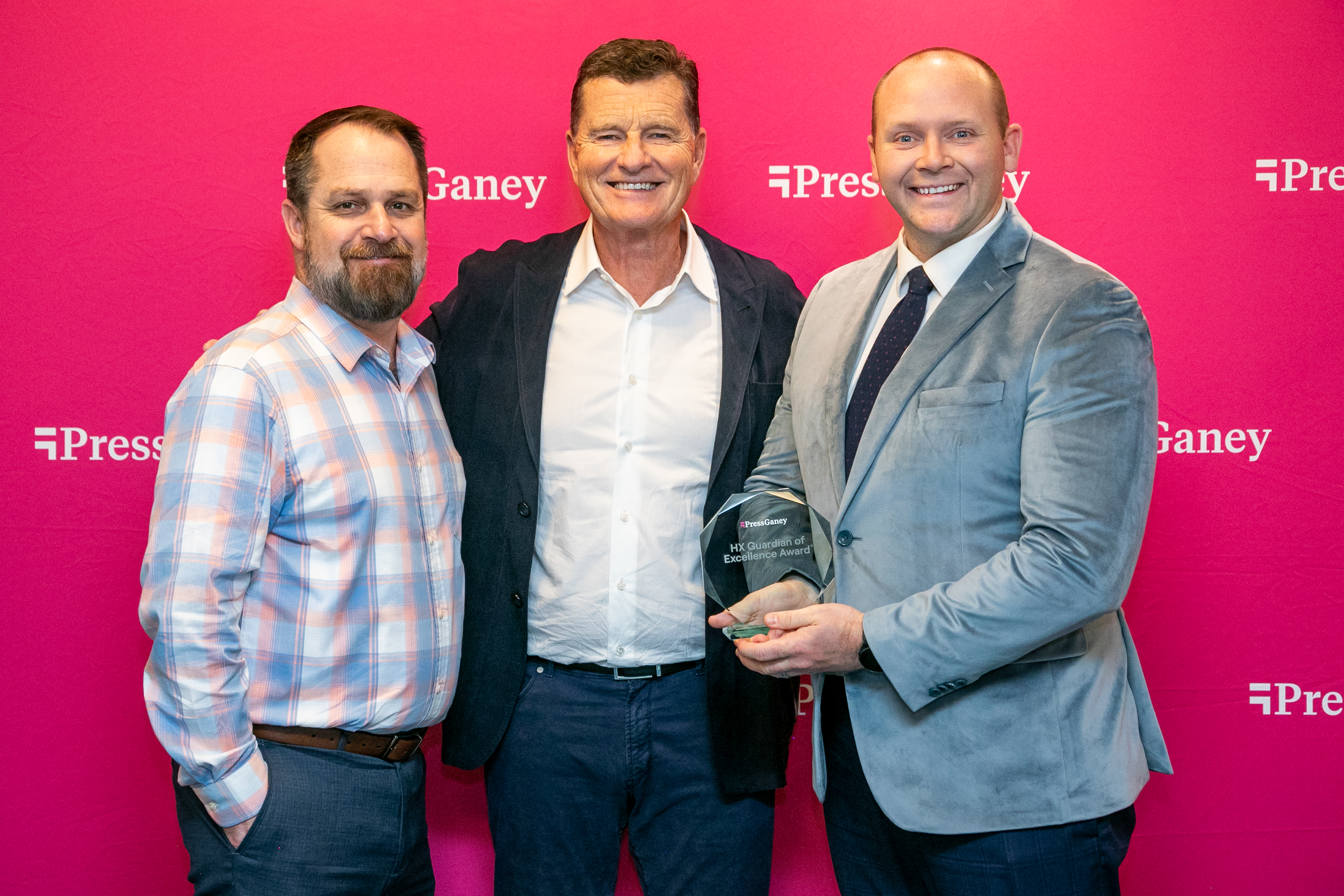 Three men from Largo West Hospital leadership standing,  smiling and holding the award from Press Gane. 