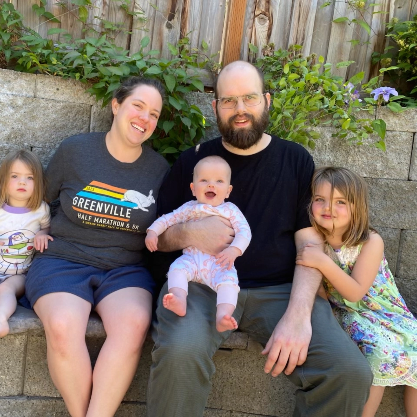 Matthew Flowers and his family sitting outside on a bench enjoying the beautiful day.