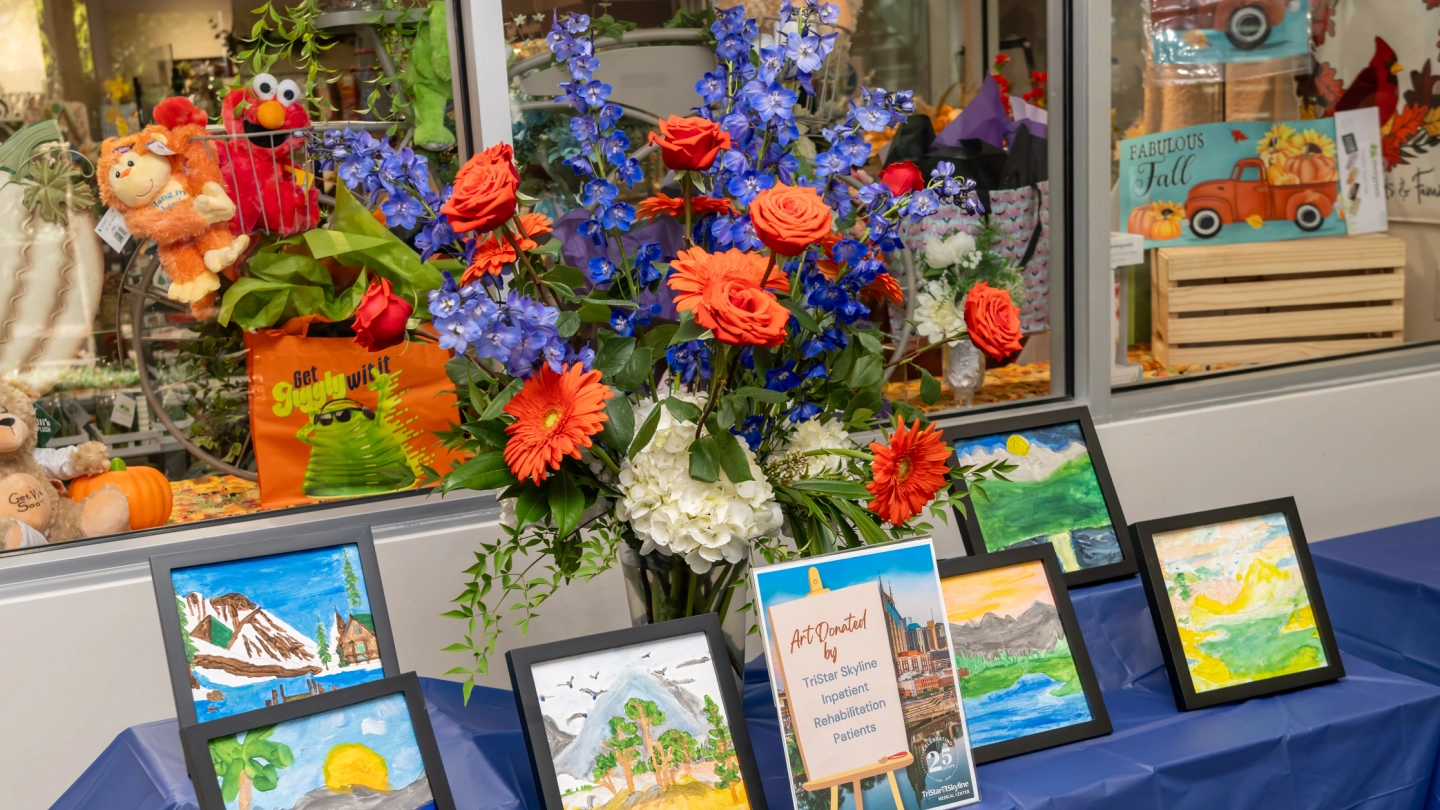 Artwork and flowers are displayed at the mural unveiling.