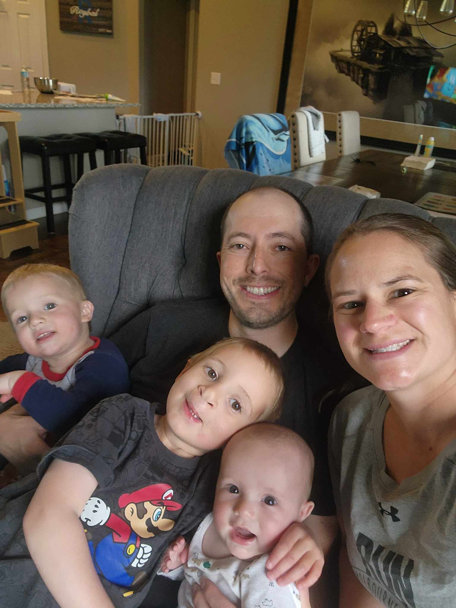Arie poses with his two brothers, mother and father on a family room chair