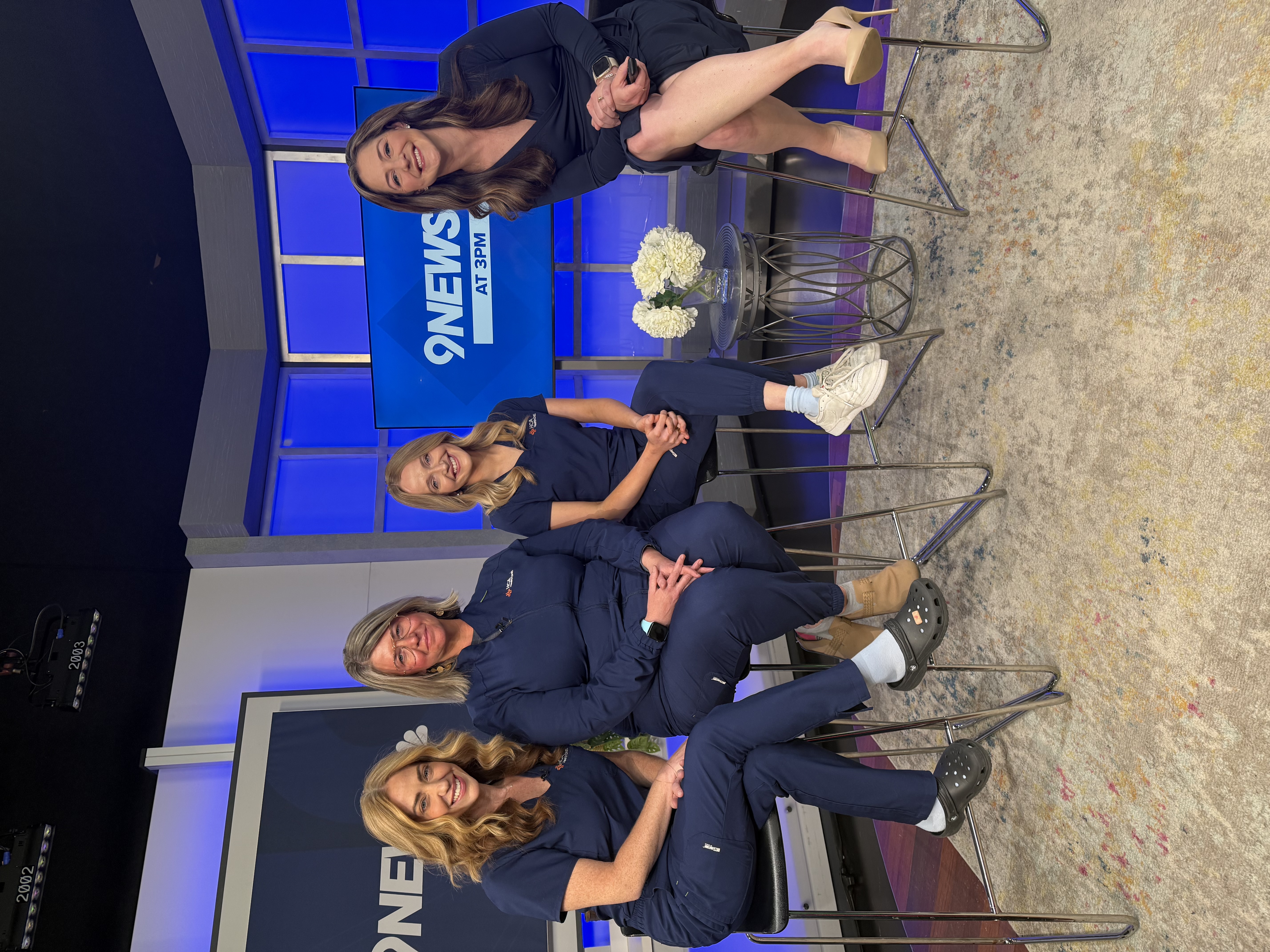 Aleyna Hearn, NICU Nurse, Theresa Keane, NICU Nurse and Sarah Richardson with the 9News host, smiling for a picture on the 9News set.