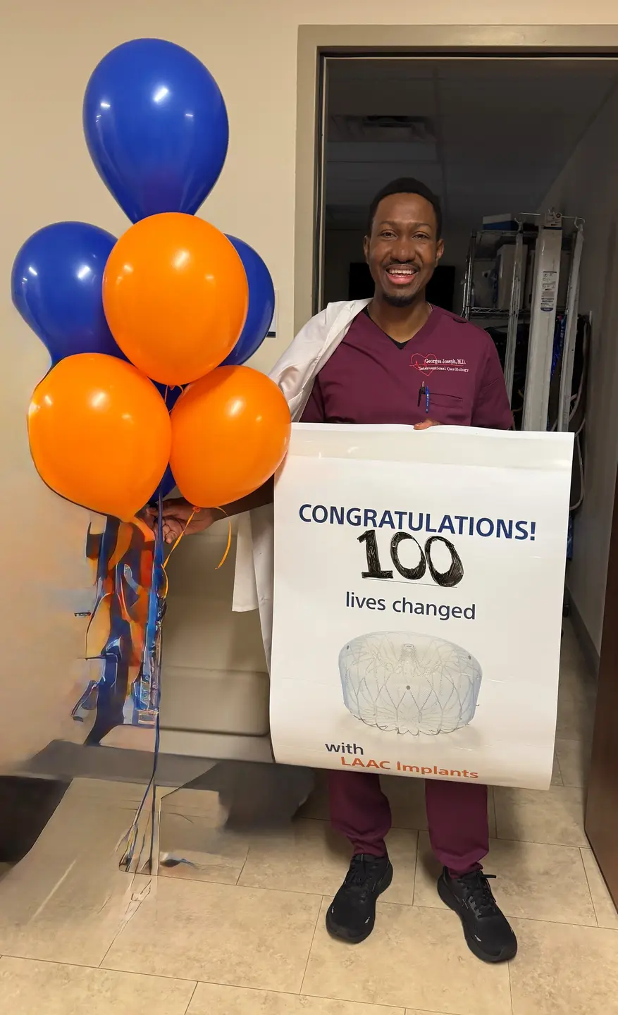 Oak Hill heart surgeon with sign that reads "100 lives changed."