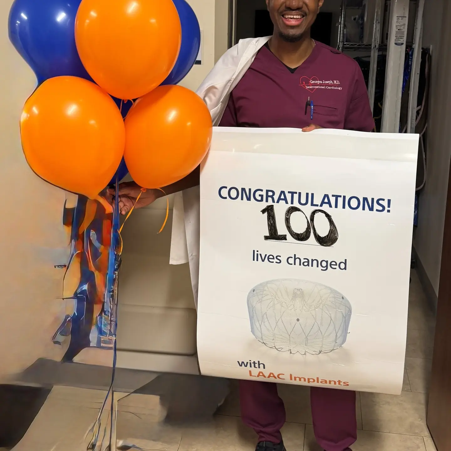 Oak Hill heart surgeon with sign that reads "100 lives changed."