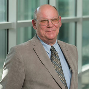 Colorectal cancer survivor Michael Deboe smiles while wearing a suit and necktie.