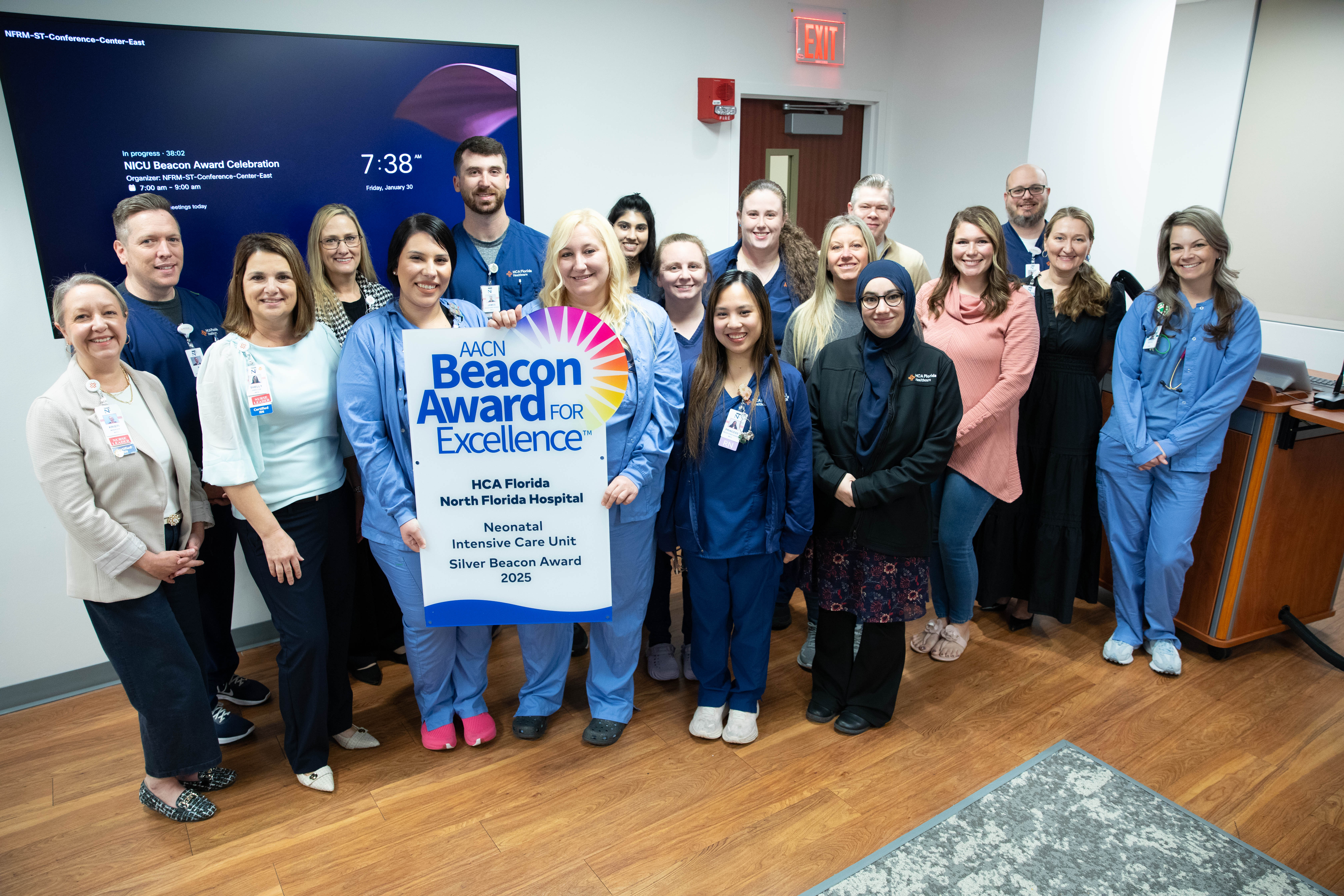 FL North Hospital NICU night shift staff posing with AACN Beacon Award for Excellence banner.