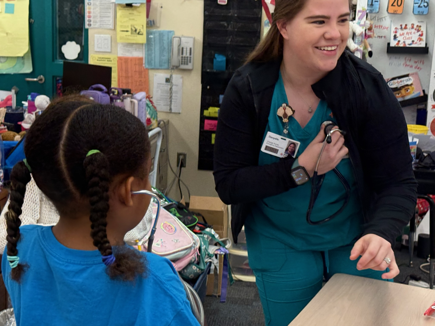 Nurse shows kids how to listen to heartbeat with stethoscope
