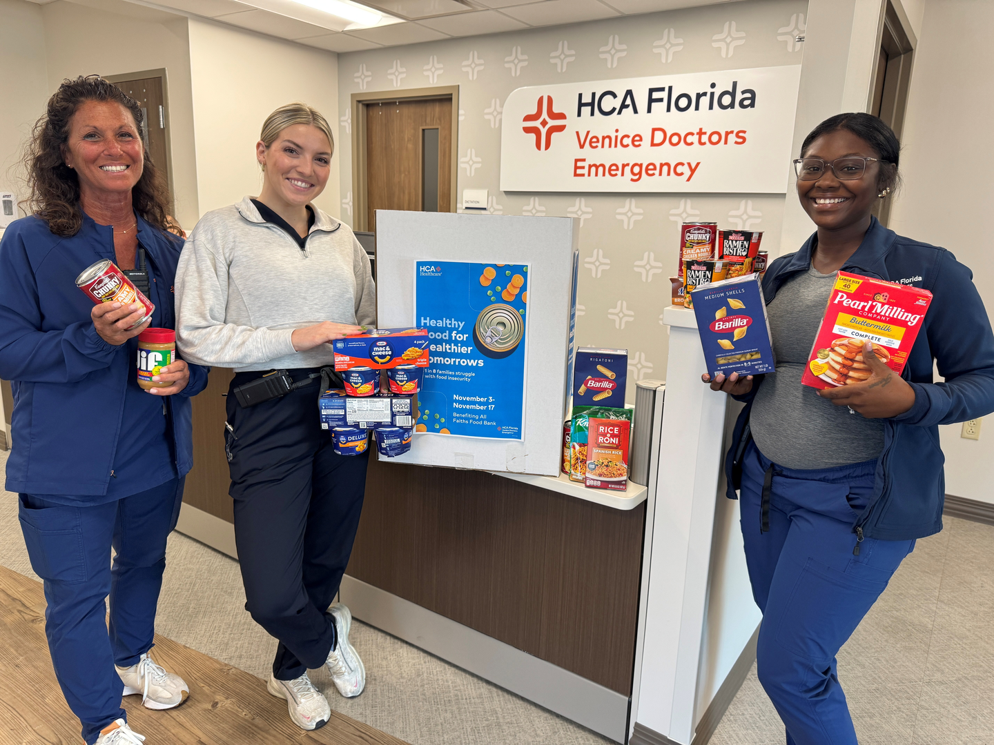 HCA Florida Venice Doctors Emergency colleagues celebrate with food items collected during food drive.