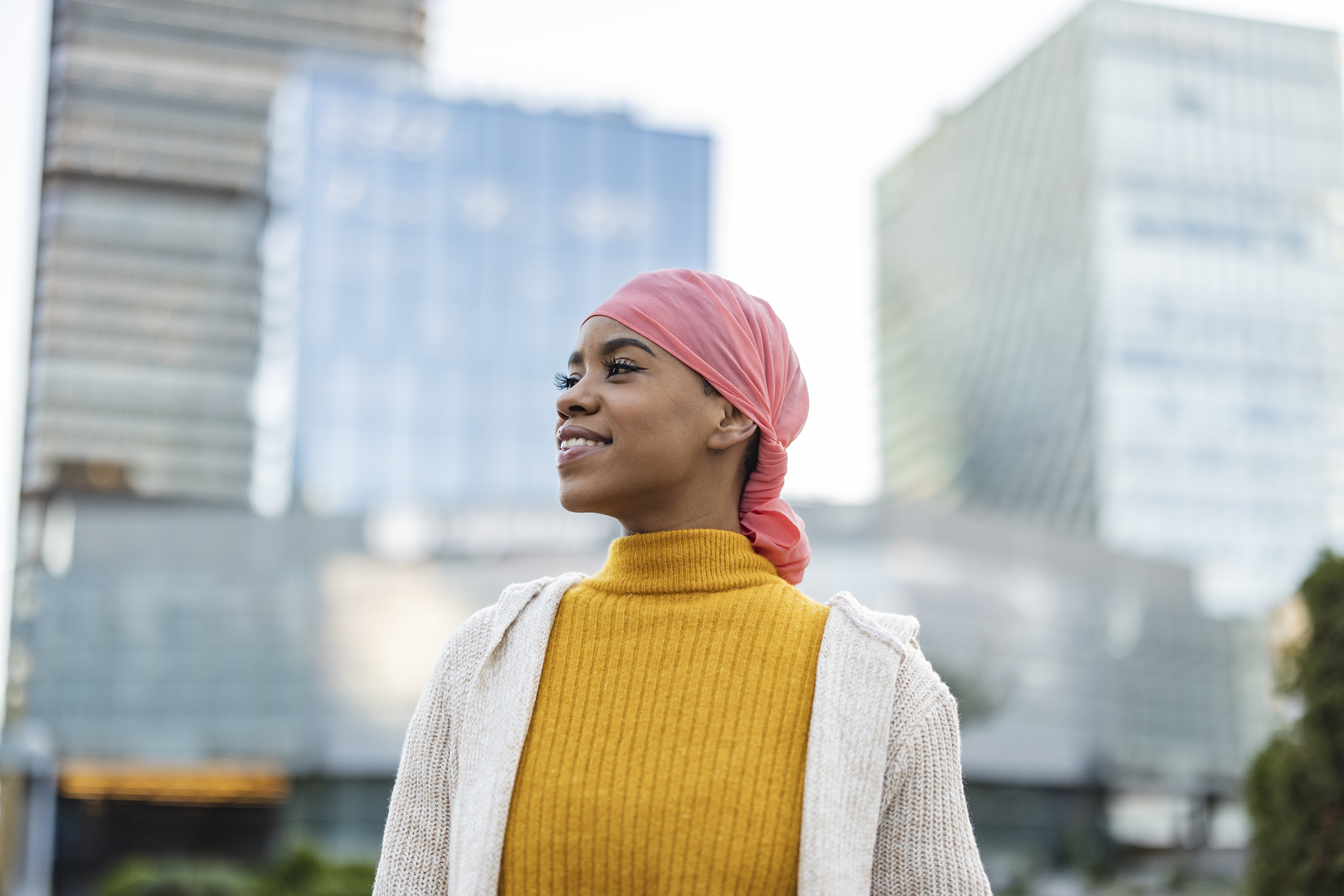 Woman wearing a sweater and scarf on her head.