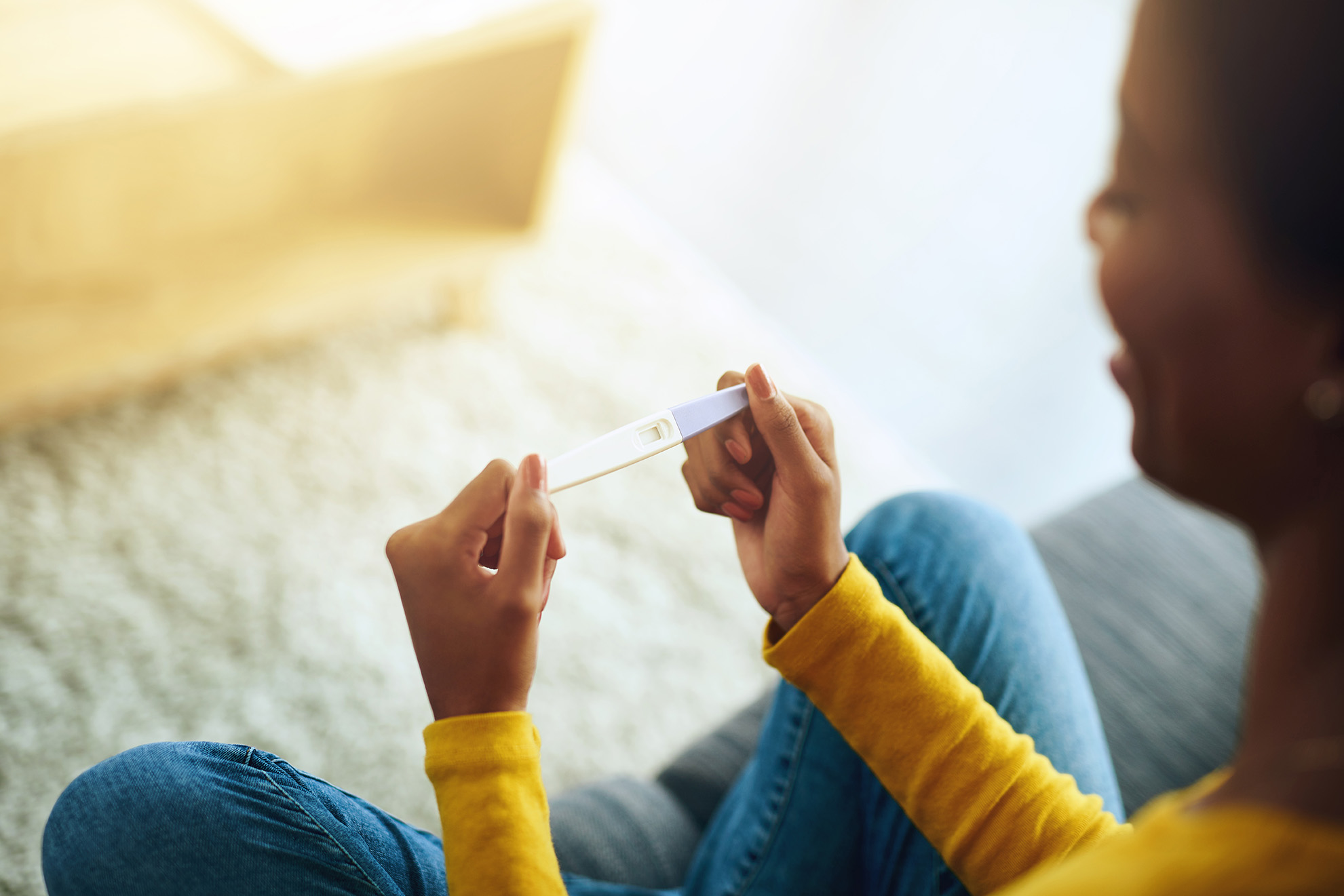 Woman smiling and holding a pregnancy test