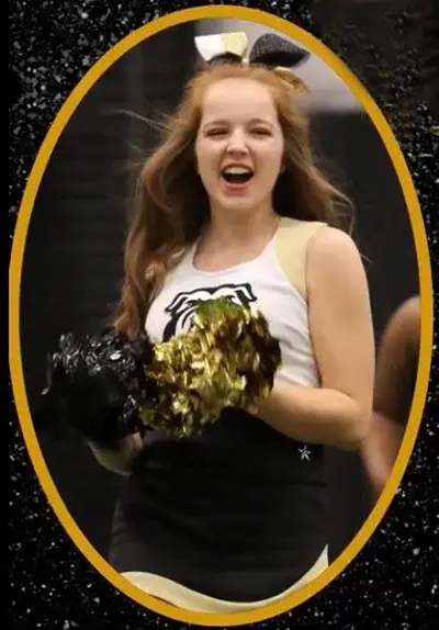 Alyssa Green smiles while cheering during a sporting event.