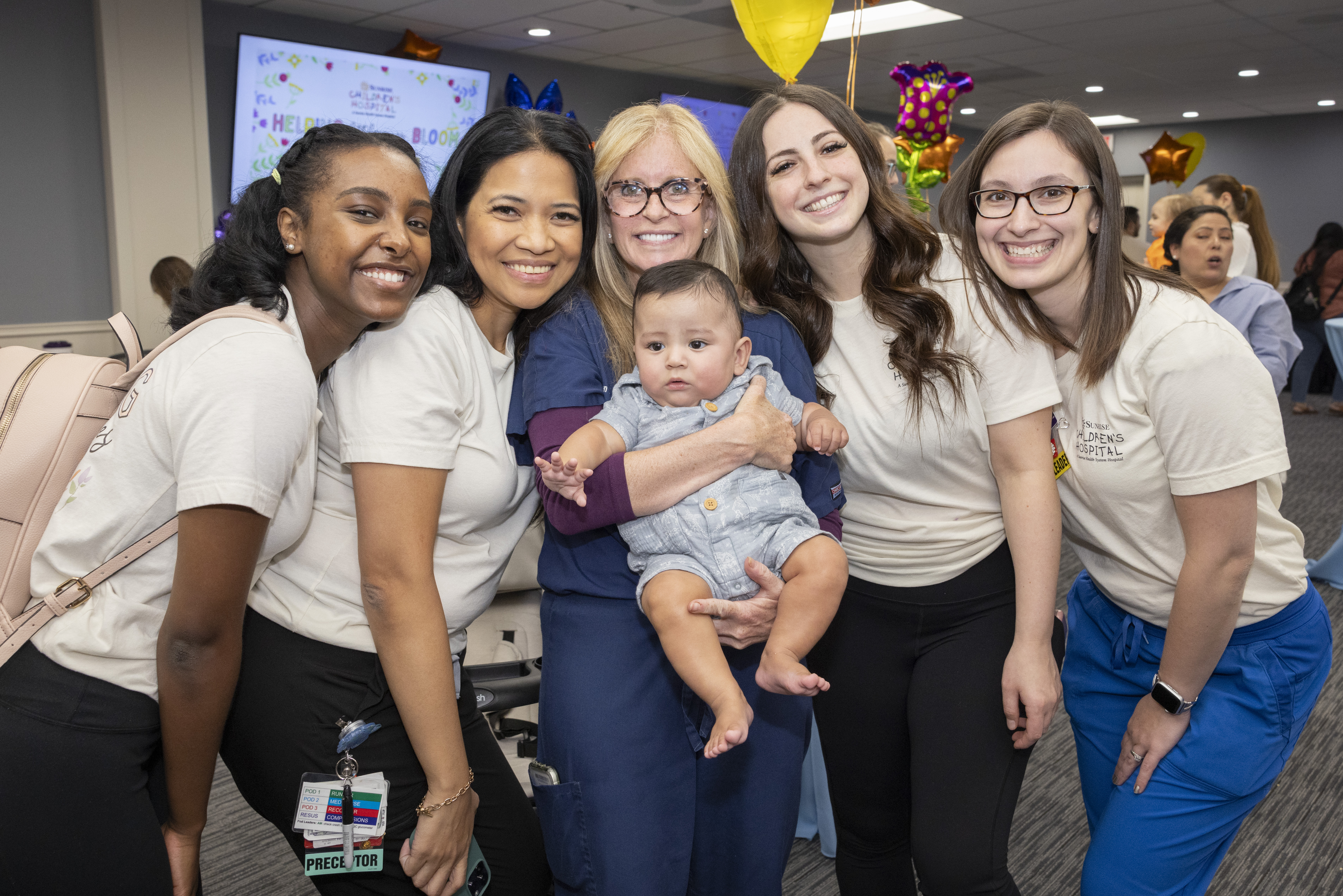 Neonatal ICU team members smile while reuniting with former patient.
