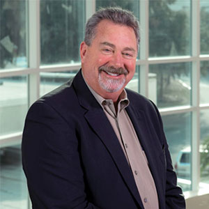 Curt Bridgett smiling and wearing a suit.