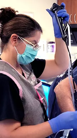 A nurse holding a tube while conducting a robotic lung bronchoscopy.
