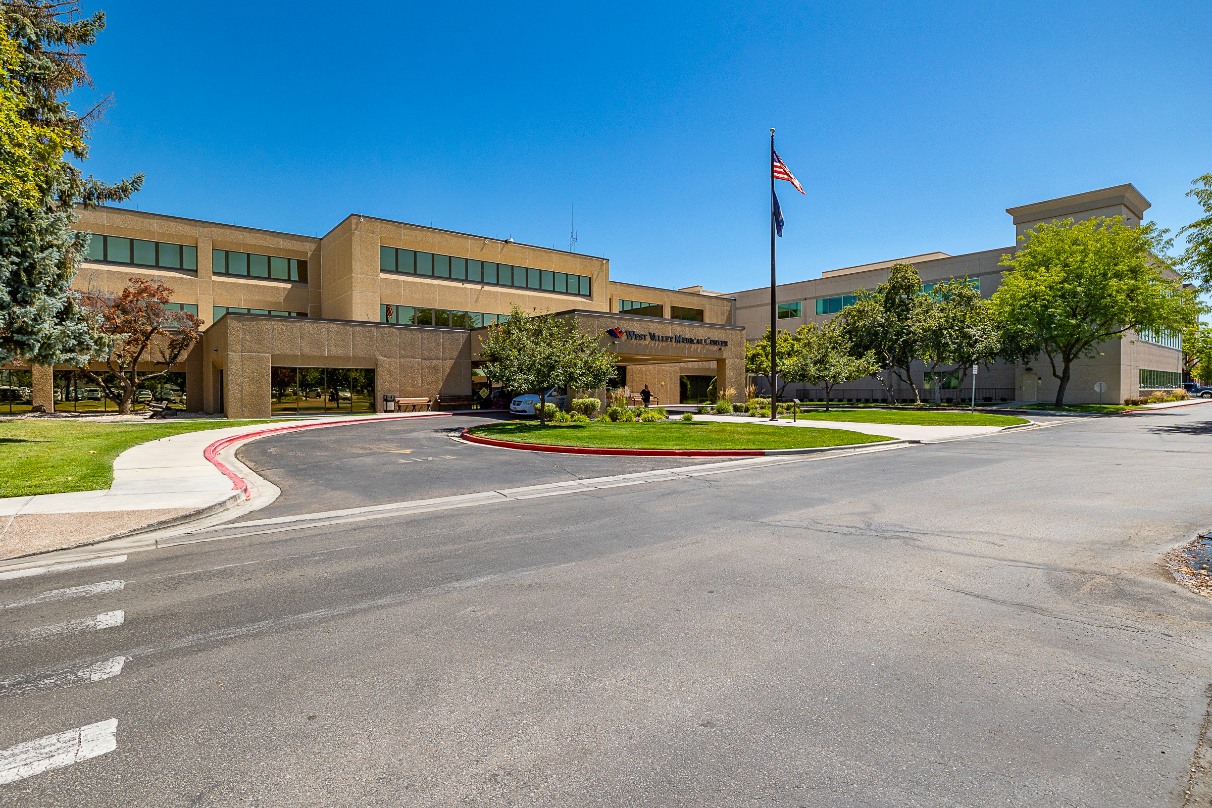 West Valley Medical Center, a brown brick building with a circle drive and a flagpole out front.