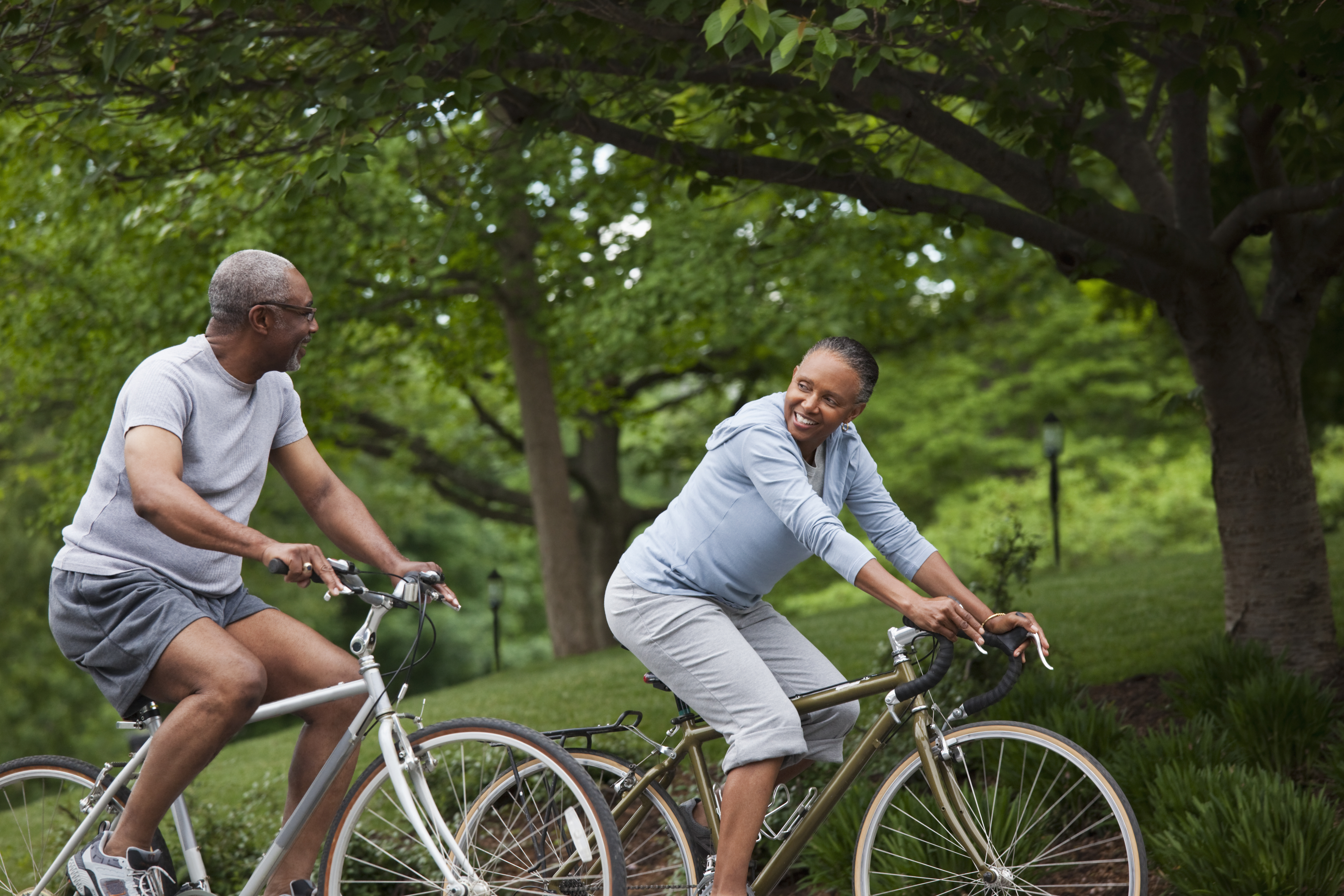 Senior couple riding bikes in a park.