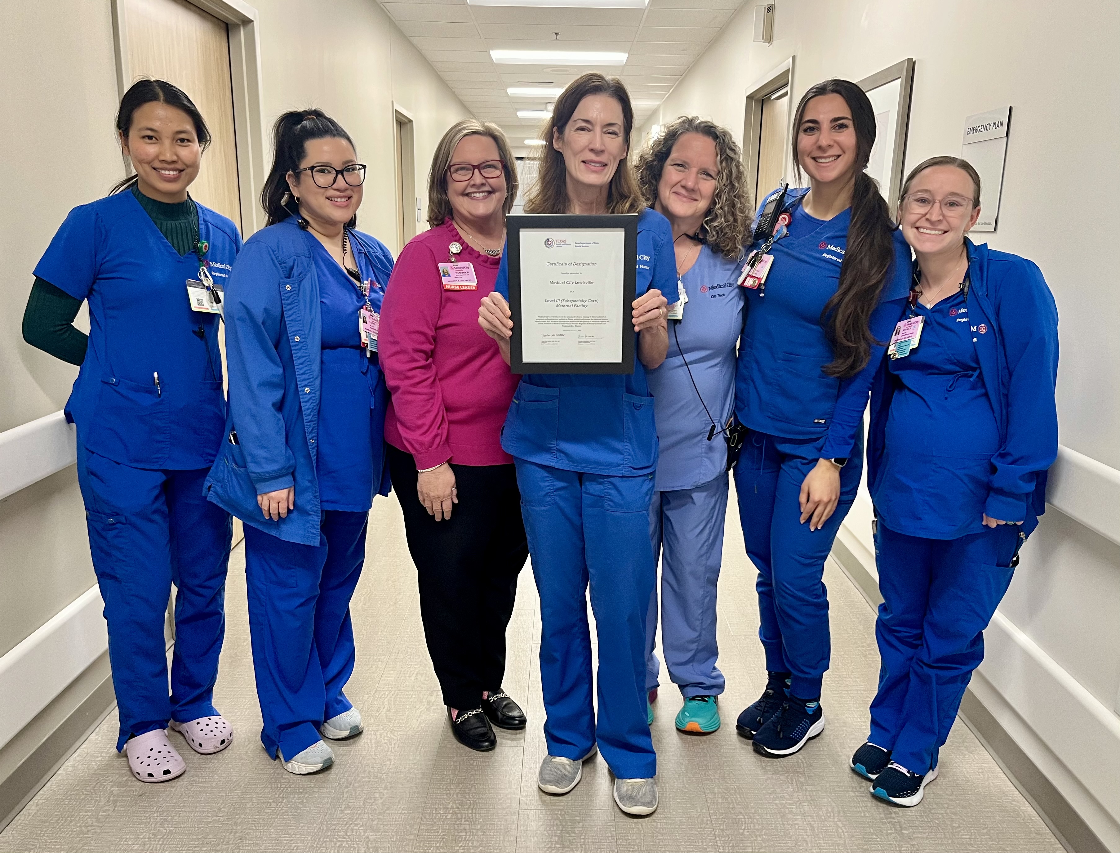 Medical City Healthcare Lewisville holding the plaque celebrating the maternal care designation.