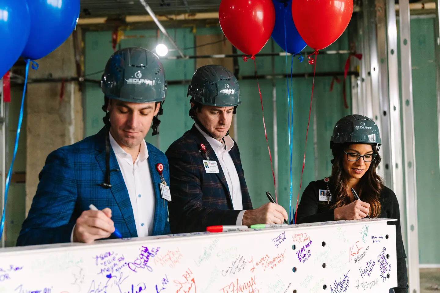 Photo of team signing the beam at the ceremony.