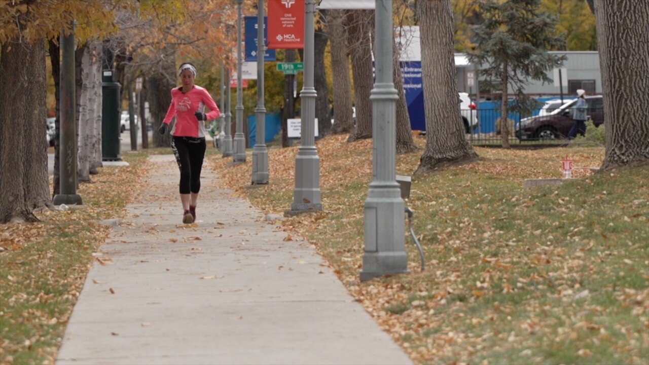Dr. Rachel Brewer in running gear running down a sidewalk