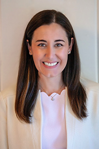 Breast surgeon Dr. Katie Bennett smiling while wearing a physician's jacket.