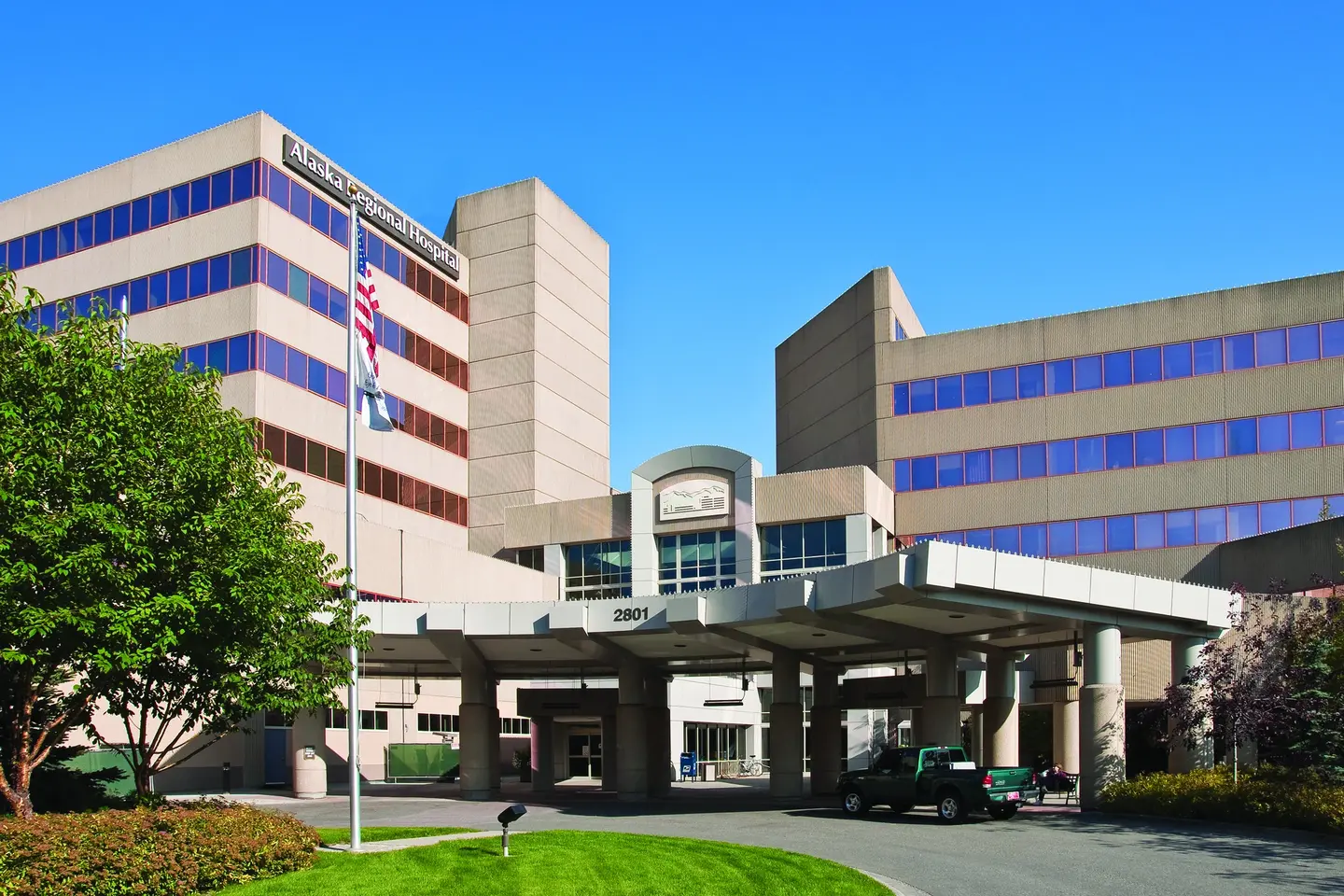 Exterior main entrance of Alaska Regional Hospital on a sunny day.