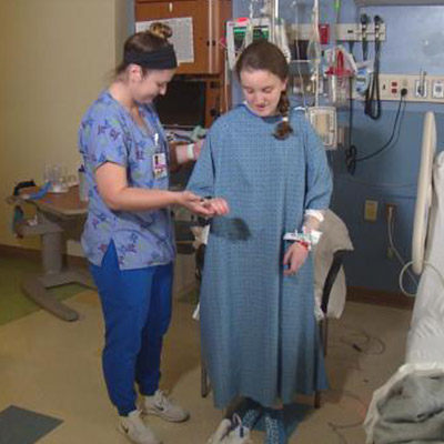 Sophia Clem being assisted by a nurse.